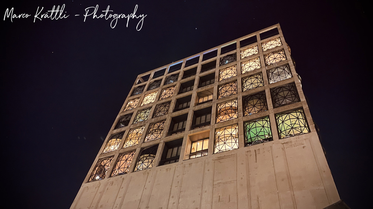 The Silo Hotel's illuminated glass windows against a night sky